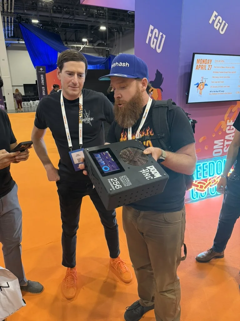 Schnitzel, Lead Maintainer of Libre Board, showing Alex Gladstein a 256 Foundation mining unit on the show floor at Bitcoin 2026